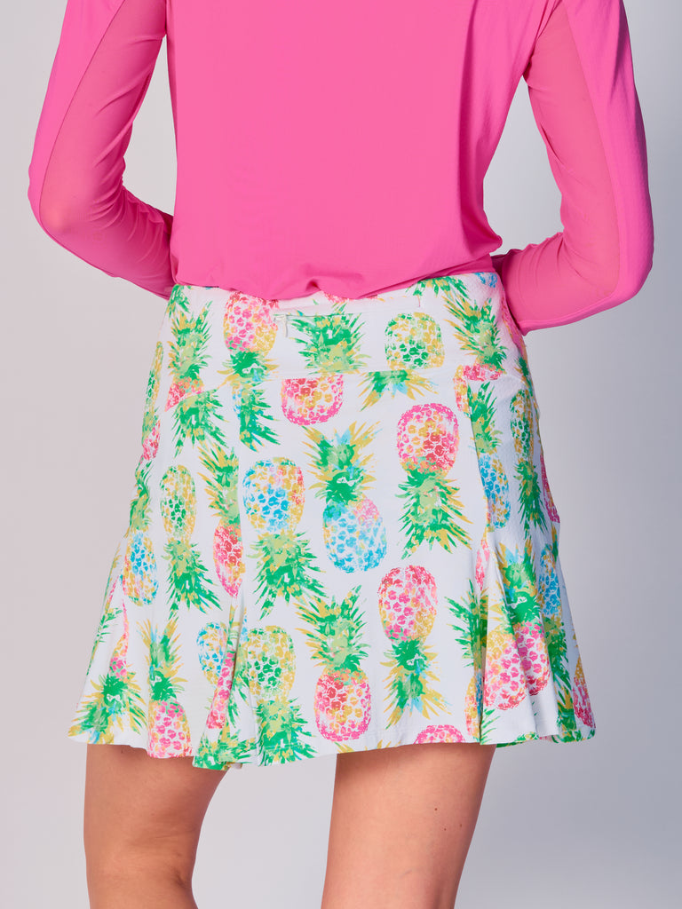 The close-up image showcases the back view of the G Lifestyle Flare Godet Skort in Ananas Green - tropical print of the Spring Summer 2024 Collection. The skort waistband is flat and wide with a single horizontal utility pocket with zip closure. The subtle texture of the soft stretchy fabric is noticeable. The stitching is meticulous, ensuring a durable and comfortable fit. This skort is suitable for tennis, pickleball, padel tennis, golf. 