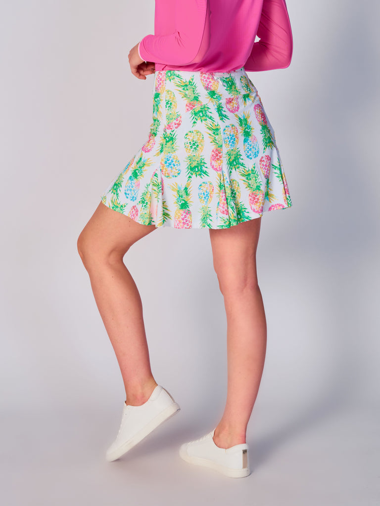 The image showcases the back view of the G Lifestyle Flare Godet Skort in Ananas Green - tropical print of the Spring Summer 2024 Collection. The skort waistband is flat and wide with a single horizontal utility pocket with zip closure. The subtle texture of the soft stretchy fabric is noticeable. The stitching is meticulous, ensuring a durable and comfortable fit. This skort is suitable for tennis, pickleball, padel tennis, golf. 