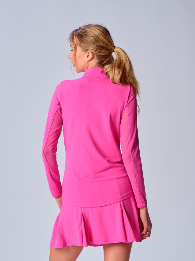 A woman is showcasing the back of the G Lifestyle Quarter Zip Sun Protection Top in Hot Pink, designed with practicality and style in mind. The top is tailored with a form-fitting silhouette, complete with long sleeves and a high collar for maximum sun protection. Notably, it includes smooth mesh underarm inserts, which are seamlessly integrated for enhanced breathability, ensuring comfort during active use. 