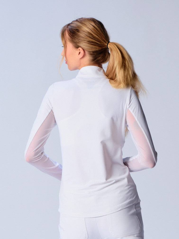 A woman is showcasing the back of the G Lifestyle Quarter Zip Sun Protection Top in White. The top is tailored with a form-fitting silhouette, complete with long sleeves and a high collar for maximum sun protection. Notably, it includes smooth mesh underarm inserts, which are seamlessly integrated for enhanced breathability, ensuring comfort during active use. 