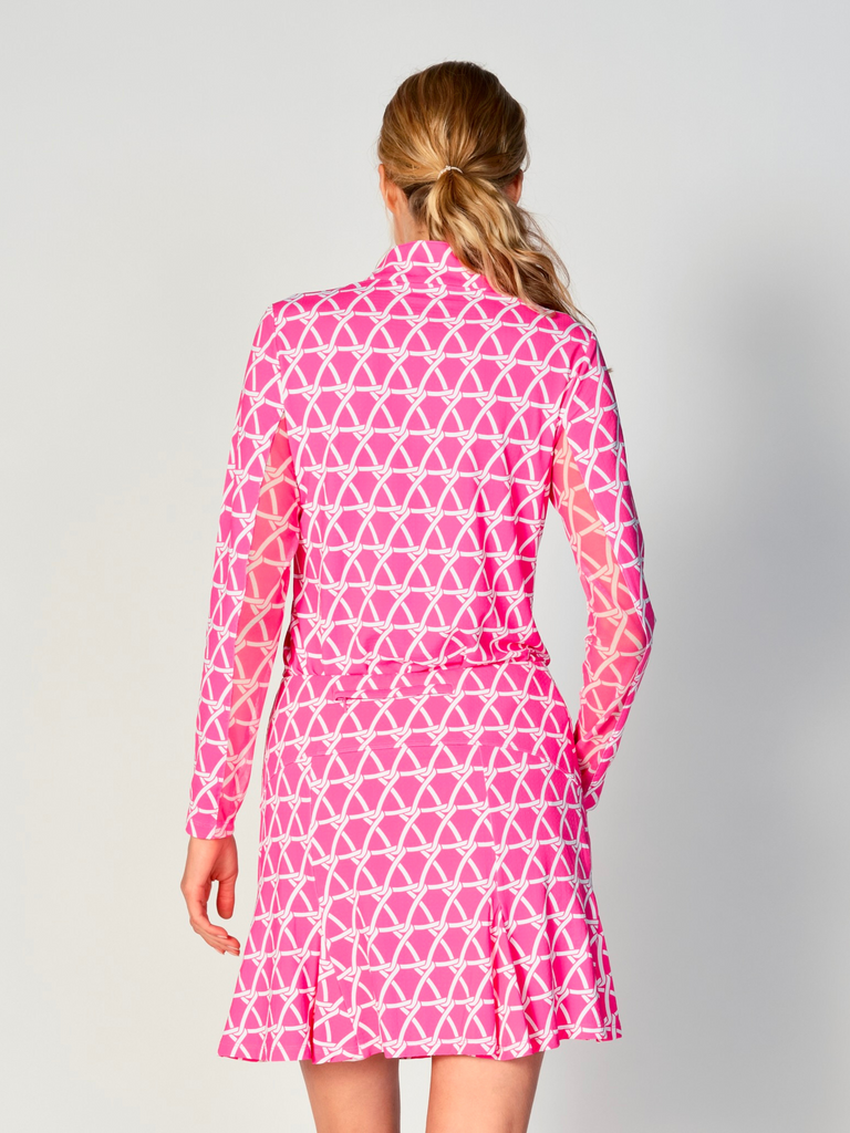 A woman is showcasing the back of the G Lifestyle Quarter Zip Sun Protection Top in Nautical Hot Pink – marine-inspired rope-knot print from Spring Summer 2024 Collection. The top is tailored with a form-fitting silhouette, complete with long sleeves and a high collar for maximum sun protection. Notably, it includes smooth mesh underarm inserts, which are seamlessly integrated for enhanced breathability, ensuring comfort during active use. 