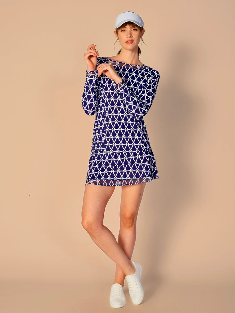 A woman wears G Lifestyle Mesh Block Long Sleeve Top in Nautical True Navy – marine-inspired rope-knot print from Spring Summer 2024 Collection. The top is designed with long sleeves, mesh underarm inserts for breathability, and features a round neckline with texture mesh block detailing around it and sleeve hems. The fabric appears to be lightweight, movement-friendly, with subtle texture. Suitable for various outdoor athletic activities such as golf, tennis, padel tennis, pickleball or even cycling.
