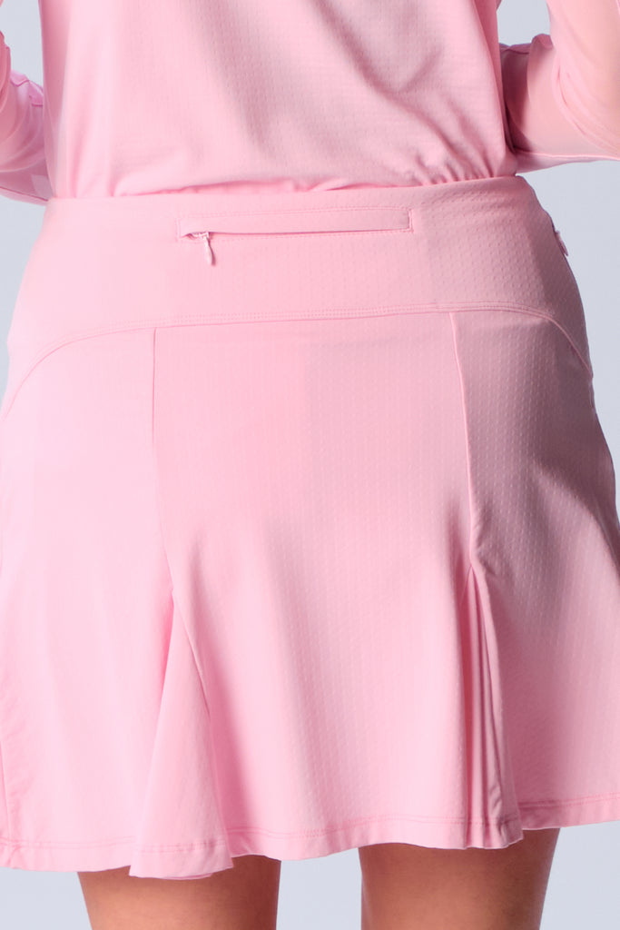 The close-up image showcases the back view of the G Lifestyle Flare Godet Skort in Light Pink. The skort waistband is flat and wide with a single horizontal utility pocket with zip closure. The subtle texture of the soft stretchy fabric is noticeable. The stitching is meticulous, ensuring a durable and comfortable fit. This skort is suitable for tennis, pickleball, padel tennis, golf. 