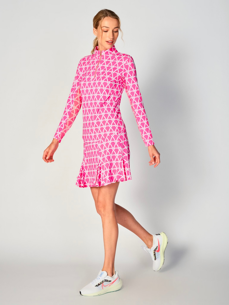 A woman pictured while twirling, showcasing the G Lifestyle Flare Godet Skort in Nautical Hot Pink – marine-inspired rope-knot print from Spring Summer 2024 Collection. This feminine and sporty skort features a fitted waistband and a flared hem with godet inserts, giving the garment playful and flirty silhouette. The length of the skort appears to be mid-thigh. The fabric looks soft, comfortable, and stretchy. This skort is suitable for tennis, pickleball, padel tennis, golf.