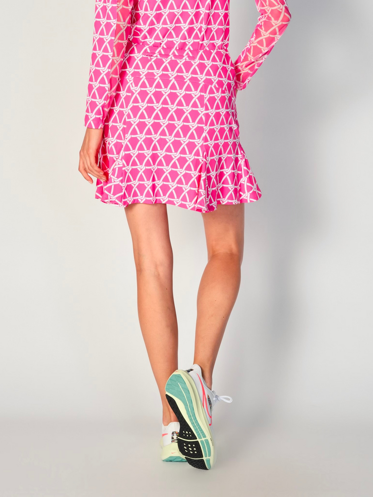 The close-up image showcases the back view of the G Lifestyle Flare Godet Skort in Nautical Hot Pink – marine-inspired rope-knot print from Spring Summer 2024 Collection. The skort waistband is flat and wide with a single horizontal utility pocket with zip closure. The subtle texture of the soft stretchy fabric is noticeable. The stitching is meticulous, ensuring a durable and comfortable fit. This skort is suitable for tennis, pickleball, padel tennis, golf. 